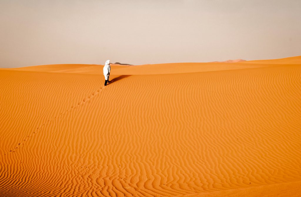 Caminhando na areia das Dunas de Erg Chebbi, Saara, Marrocos.