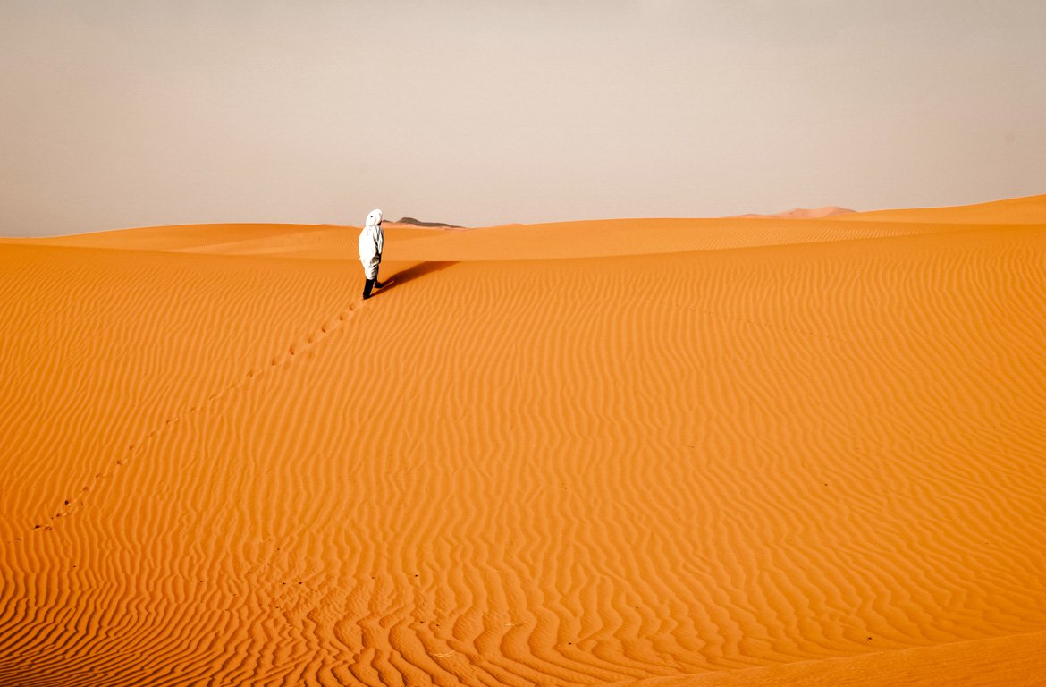 Caminhando na areia das Dunas de Erg Chebbi, Saara, Marrocos.