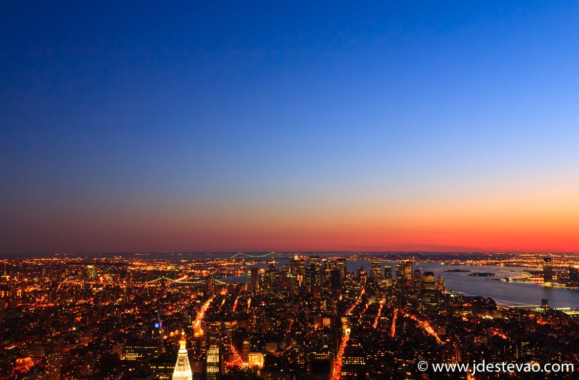 Vista área, ao pôr-do-sol, da cidade Nova Iorque, Estados Unidos da América