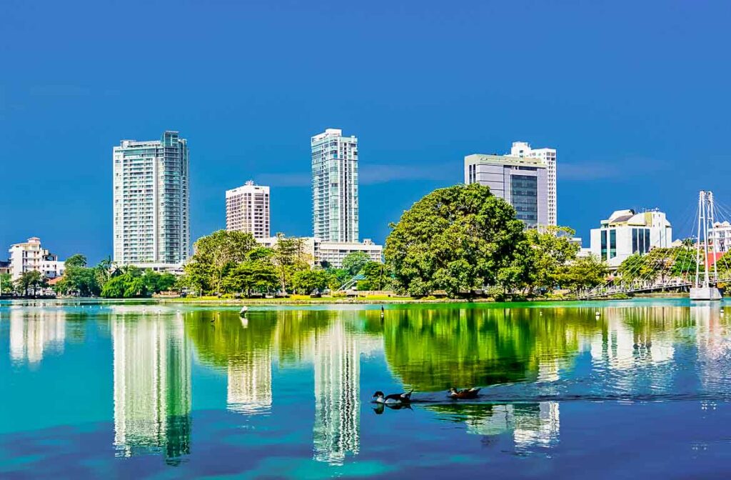 A beleza de Colombo, Sri Lanka, vista do Lago Beira, calmo, com edifícios imponentes e árvores frondosas.