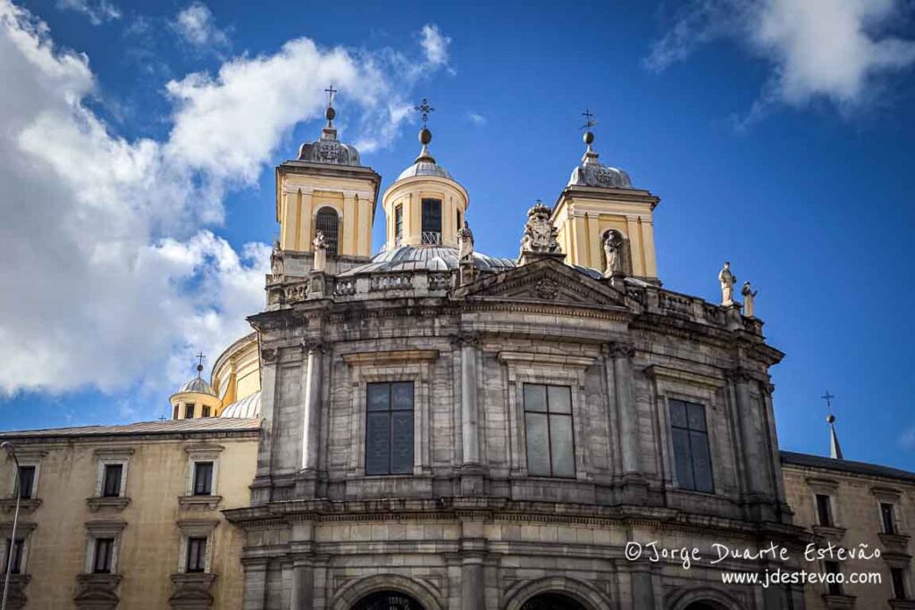 Fachada imponente da Real Basílica de San Francisco el Grande em Madrid, destacando as suas torres e cúpula monumental sob um céu azul com nuvens. Um tesouro da arquitetura neoclássica para visitar em Madrid.