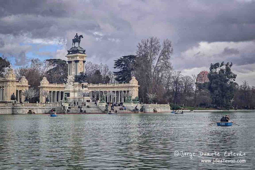 Turistas em barcos a remo no lago do Parque do Retiro, com o Monumento a Afonso XII ao fundo; uma das atividades de lazer mais populares para quem visita Madrid.