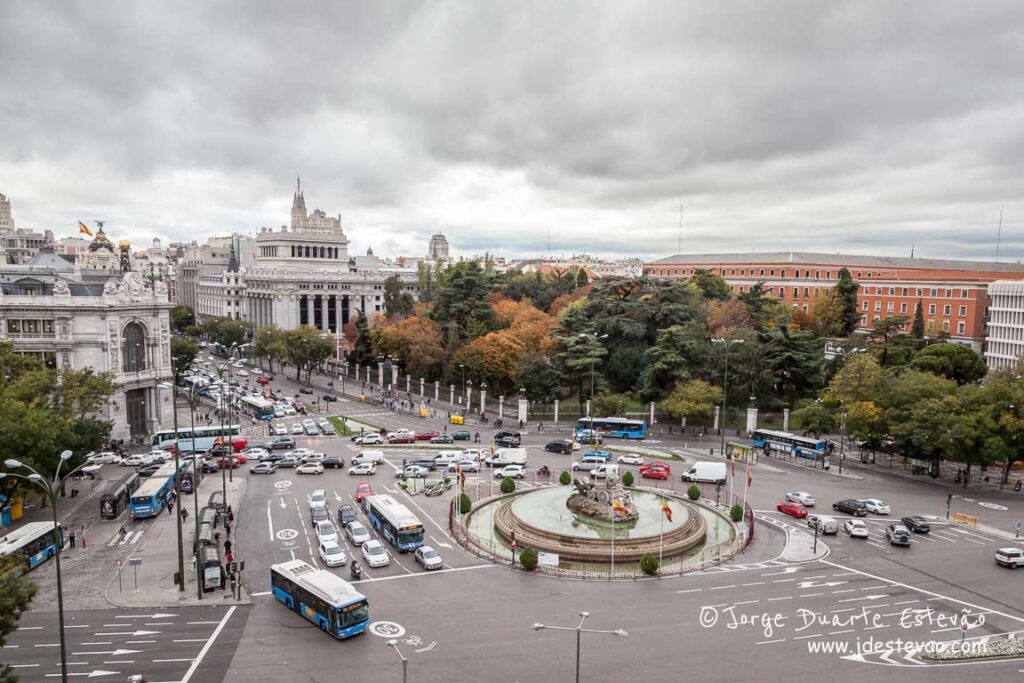 Vista aérea da Praça de Cibeles em Madrid, destacando a fonte icónica e a arquitetura monumental do Palácio de Cibeles sob um céu azul. Um dos cruzamentos mais bonitos para visitar em Madrid.